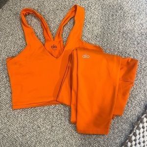 Alo bright orange workout set. Crop bra mid length and high waisted leggings.